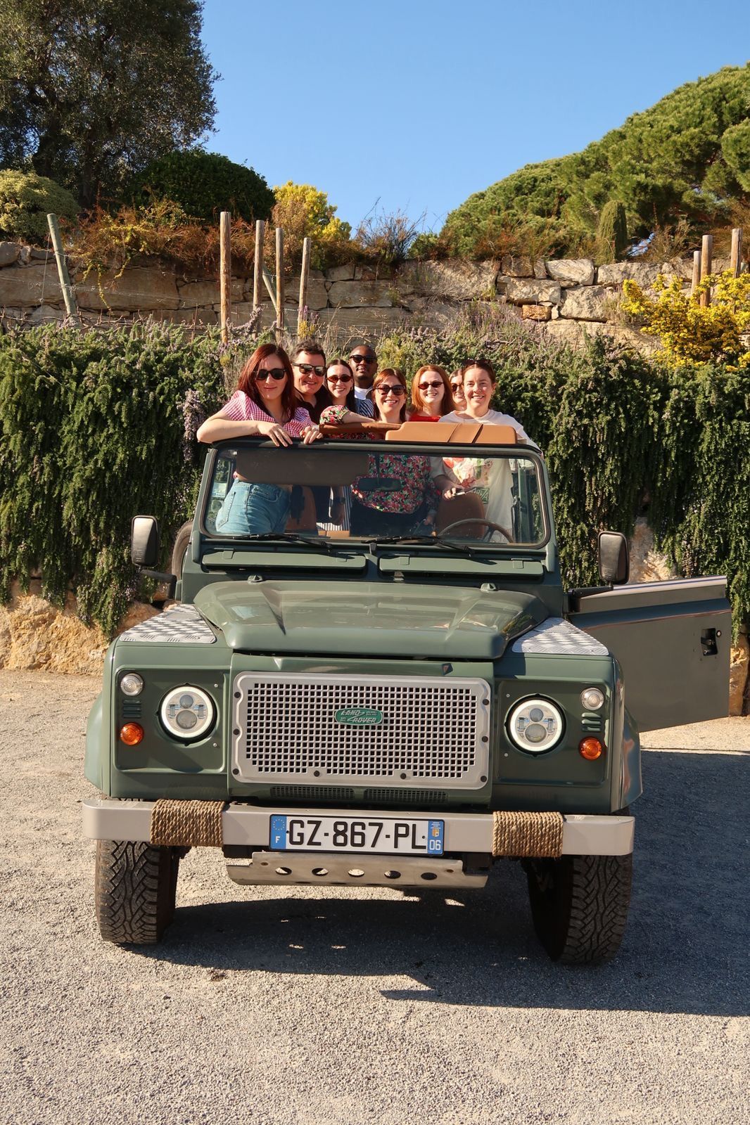Groupe d'invités à bord du Defender, devant les vignes du Château de Crémat